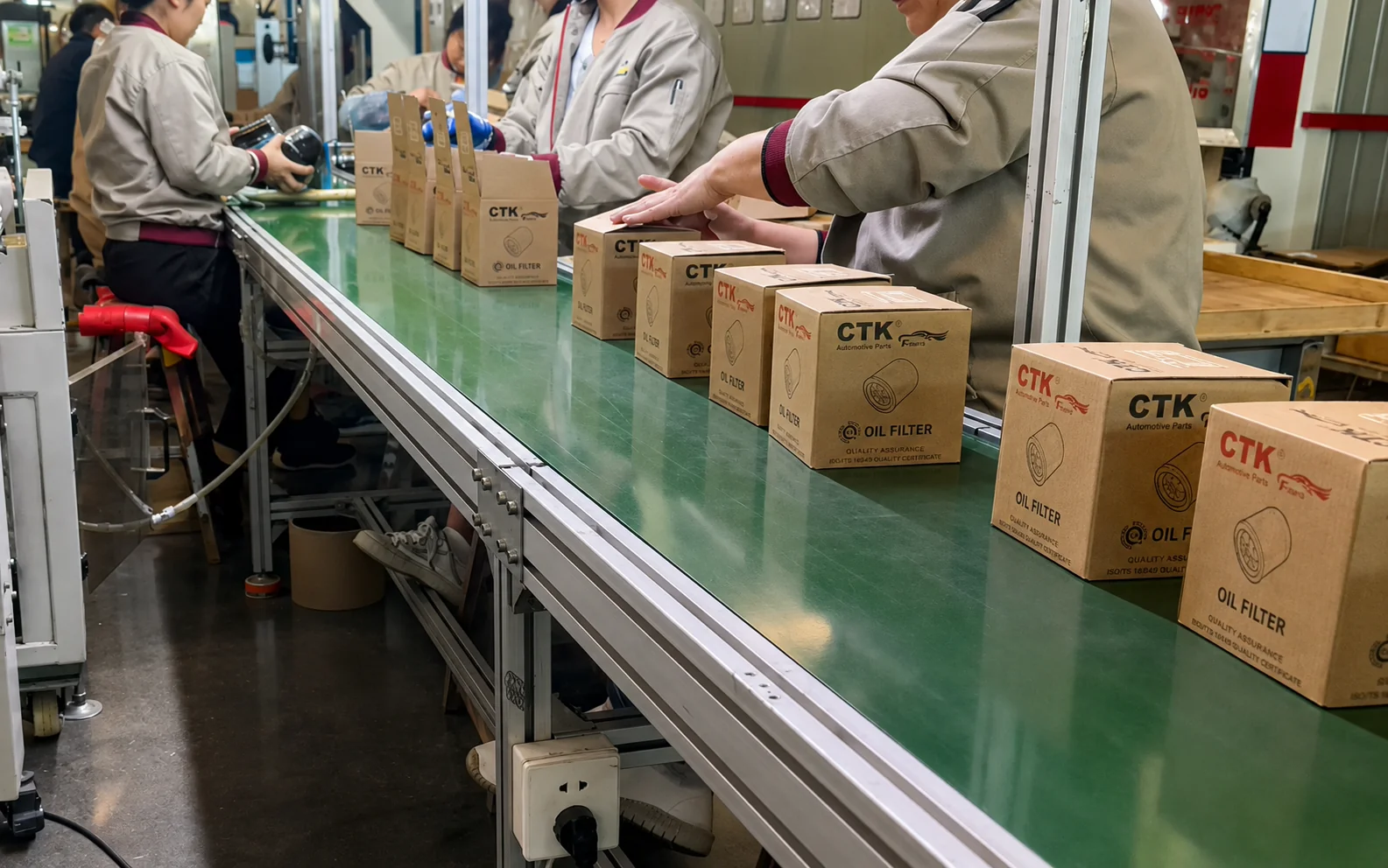 Workers packing automotive oil filters into branded unit boxes